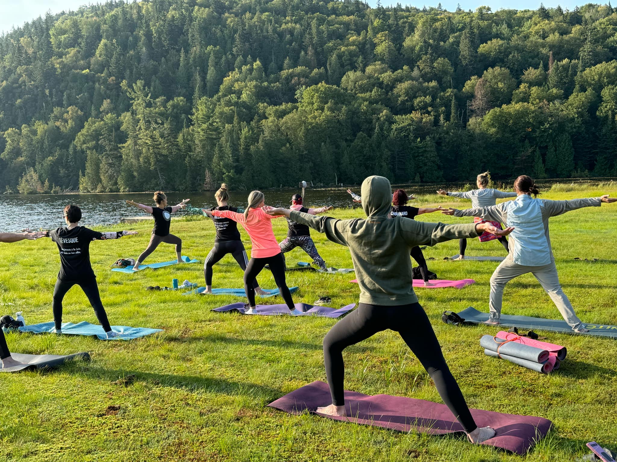 Groupe de femmes faisant du yoga au bord d'un lac