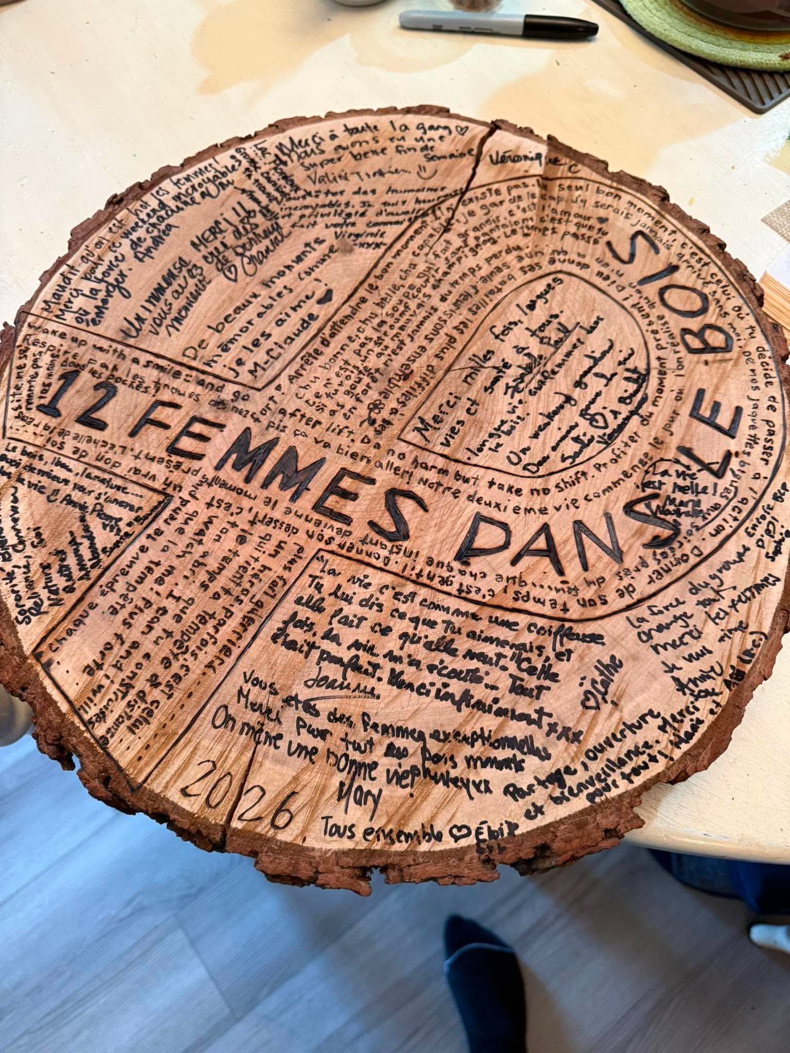Rondin de bois gravé avec les messages et souvenirs des participantes de 12 femmes dans le bois
