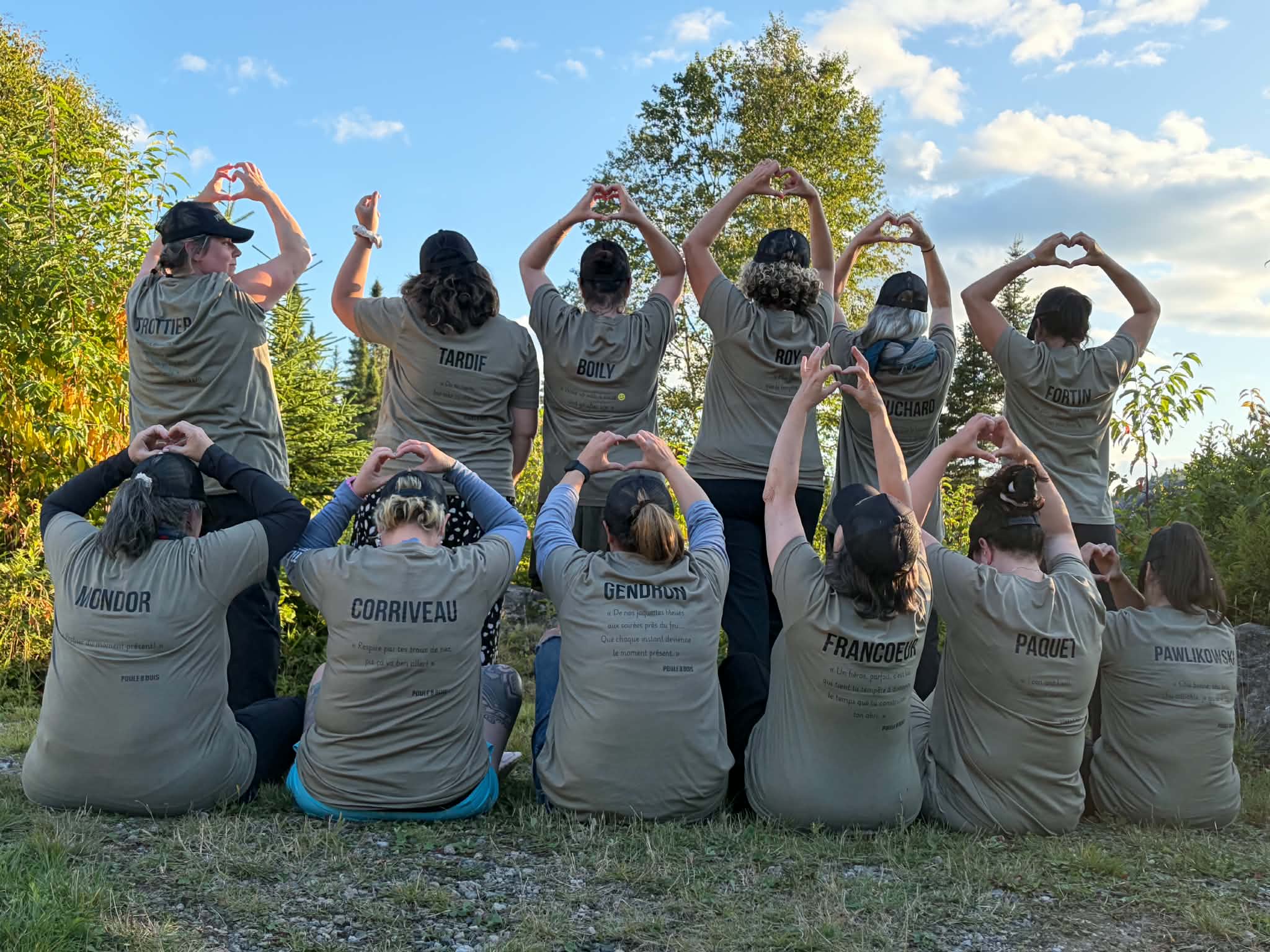 Photo de groupe de femmes formant des cœurs avec leurs mains dans la forêt